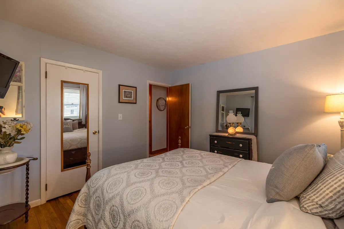 A tranquil bedroom featuring a comfortable bed with soft bedding, a nightstand with a glowing lamp, and calming wall art. The peaceful ambiance and thoughtful decor create a relaxing environment ideal for a private retreat.